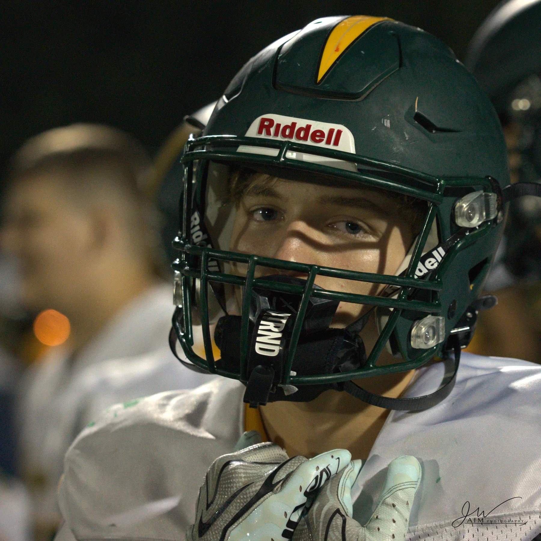 Football athlete standing ready beneath stadium lights